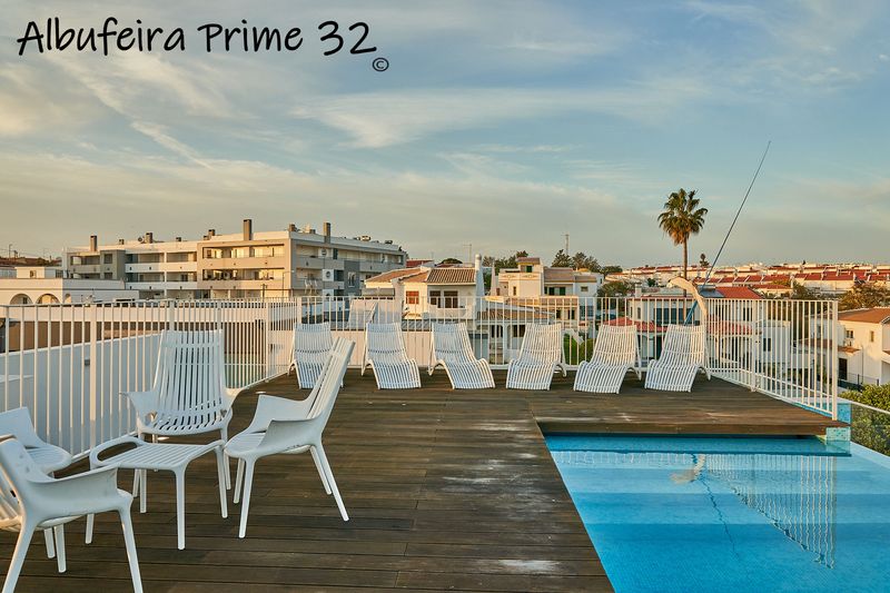 Sun loungers on the deck beside the rooftop communal pool