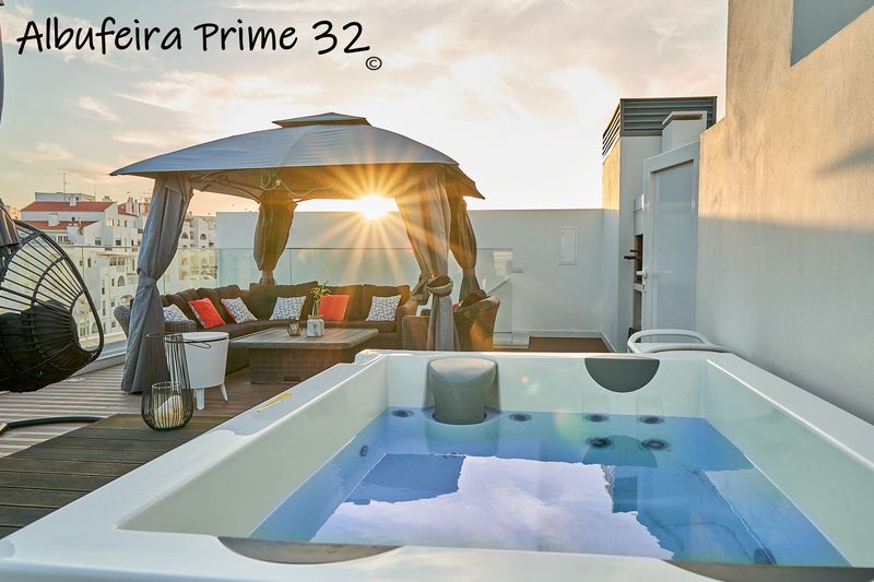 Private roof terrace with hot tub and gazebo at sunset